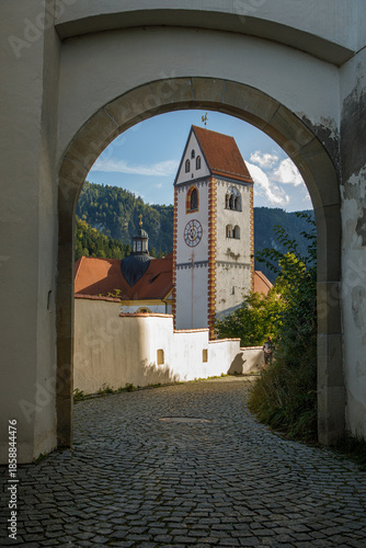 Scenic View of St Mang Basilica Tower through Stone Arch in Fussen, Germany