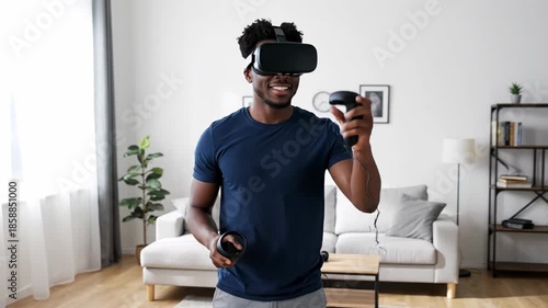 Young man using virtual reality headset at home living room