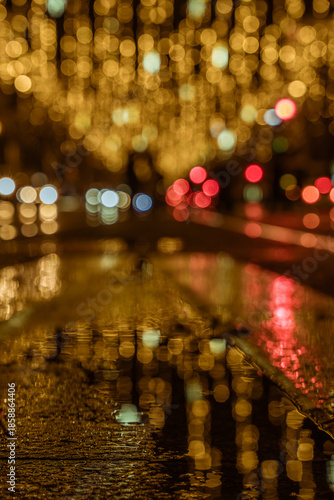 Christmas lights in 'Paseo Independencia' in Zaragoza, Aragon, Spain. Night picture. Rainy day. Reflections.