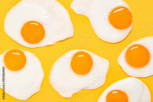 Tasty fried eggs on yellow background