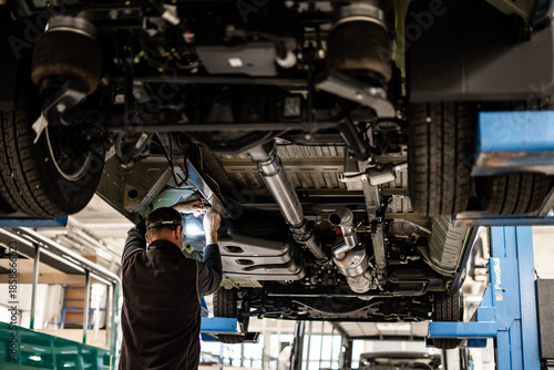 Industrial vehicle manufacturing workshop with metal bus frames and body structures under assembly. Large factory interior shows fabrication, welding, and custom vehicle production in progress.