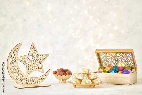 Ramadan kareem background . Crescent moon decor decor with dates , maamoul semolina cookies and chocolate candy