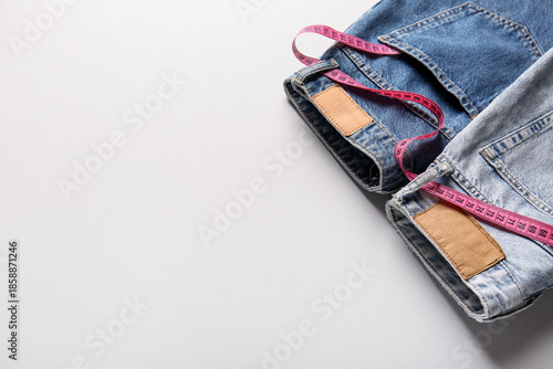 Wallpaper Mural Different denim jeans with measuring tape on grey background. Anorexia concept Torontodigital.ca
