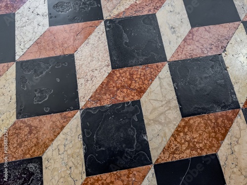 Colourful marble floor in ancient church with white, orange and black tiles
