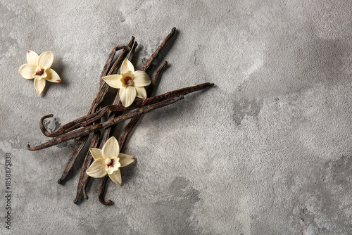 Heap of vanilla sticks and flowers on grunge background © Pixel-Shot