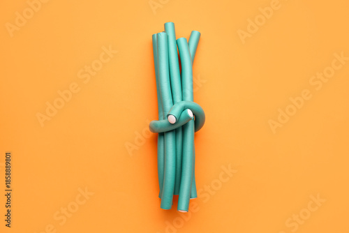 Hair curlers on orange back...