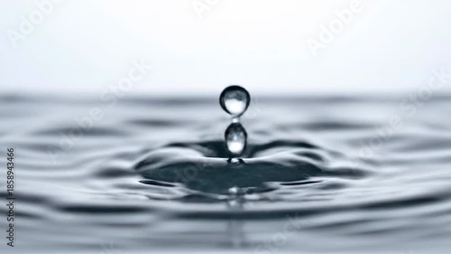 A mesmerizing close-up of a single water droplet impacting a calm surface, creating a perfect, symmetrical crown splash with intricate details and a clear reflection, captured in high-speed photograp.