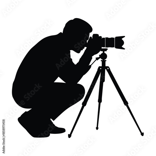 Silhouette of a photographer kneeling with a camera on a tripod