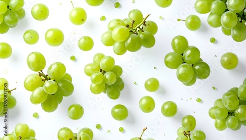 Overhead view of scattered green grapes & individual spheres on clean white background