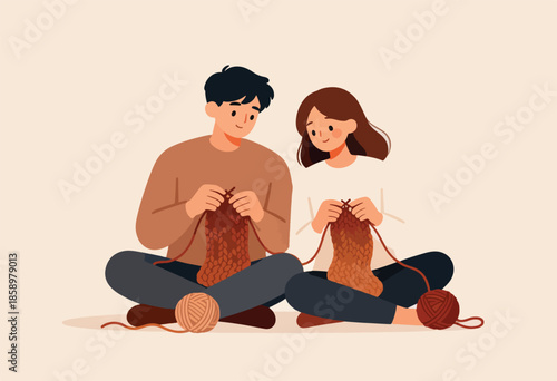 A couple sits cross-legged, engrossed in knitting together, surrounded by yarn