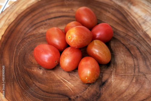 Cherry tomatoes on wooden background Close-up of fresh red tomatoes on wooden board. Kitchen food preparation vegetables. 
