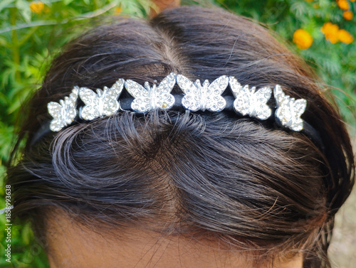 Dark Hair Adorned with a Sparkling Silver Butterfly Headband Accessory