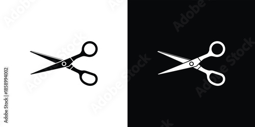 Pair of black and white scissors on contrasting backgrounds