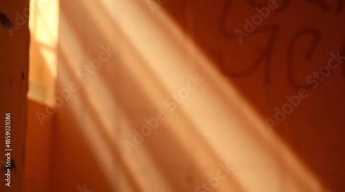 Sunlight streaming through a window illuminating a bed with white linens.