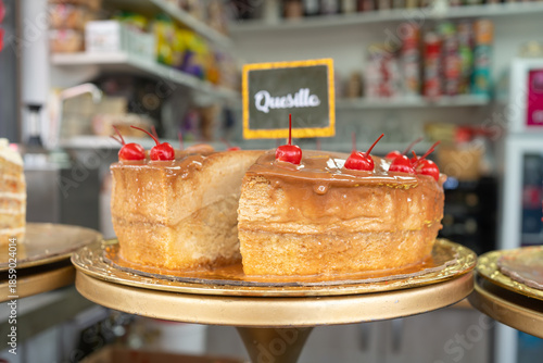 En la pastelería hay un quesillo venezolano cubierto con caramelo y cerezas para el postre.