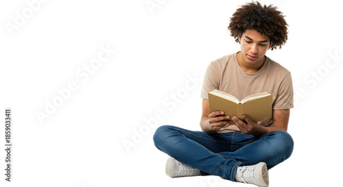 Young man with afro hair sitting cross legged on the floor reading a book isolated on transparent background