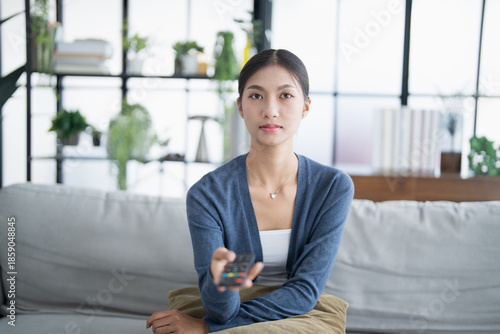 Asian woman Watching smart TV and using remote controller Hand holding television audio remote control at home with the remote control television Free Download Asian woman Watching smart TV and using remote controller Hand holding television audio remote control at home with the remote control television - GFXLoad