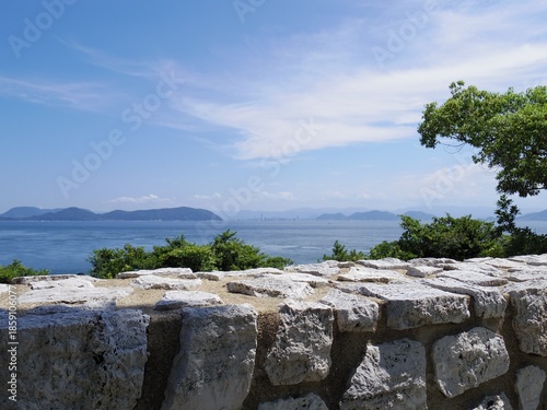 海岸の石垣越しに見る青い海と空