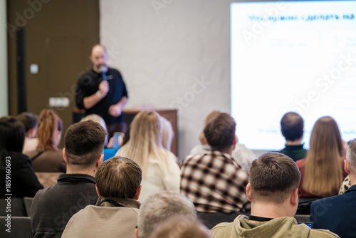 Wallpaper Mural Vibrant conference room scene shows presenter addressing attentive audience during seminar with bright screen. Professional atmosphere highlights learning, collaboration, and business communication. Torontodigital.ca