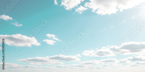 A bright and vibrant turquoise blue sky filled with scattered white cumulus clouds on a clear day