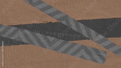 Textured paper composition with ruler marks and decorative striped grey tape overlapping brown and dark grey surfaces