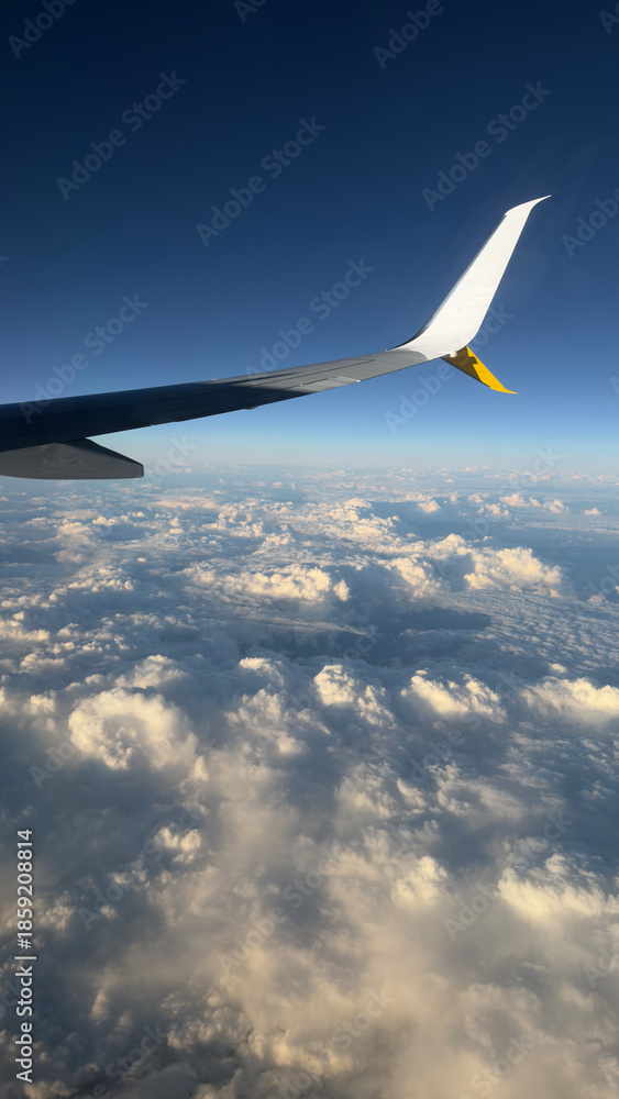 Fototapeta premium An airplane wing above the clouds over the Mediterranean Sea