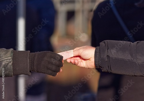 Close-up of hands exchanging cash during a purchase at an outdoor Naplavka farmers market in cold winter, illustrating direct payment, small business sales and everyday financial transaction.