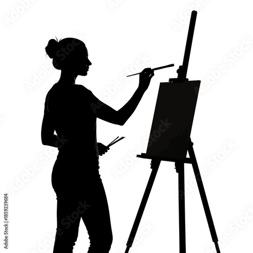 Silhouette of a woman artist painting at an easel in a studio