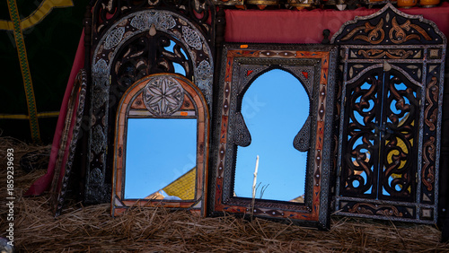 Three ornate mirrors reflecting the sky.