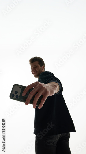 Close view of smartphone held by men toward camera. Concept of mobile camera advertising, smartphone feature highlight, and hardware detail promotion.