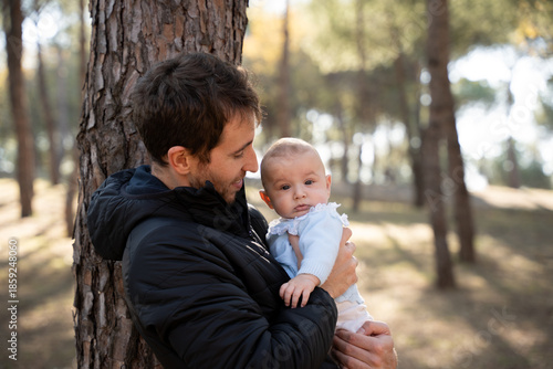 Father holding baby in urban park sharing loving moment