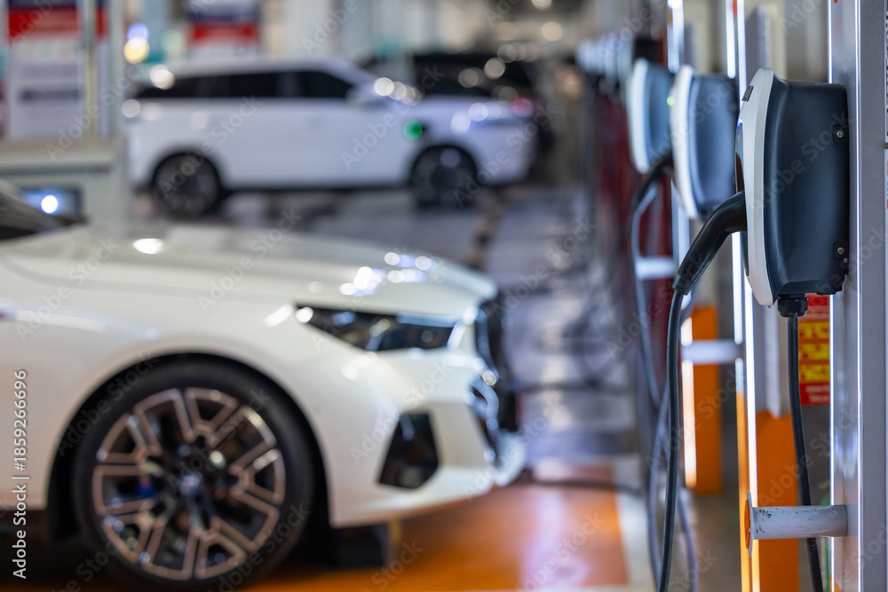 Obraz premium EV charging and electric car, Electric car charging station for charge EV battery, Plug for vehicle with electric engine, EV charger clean energy, Charging point at car parking lot