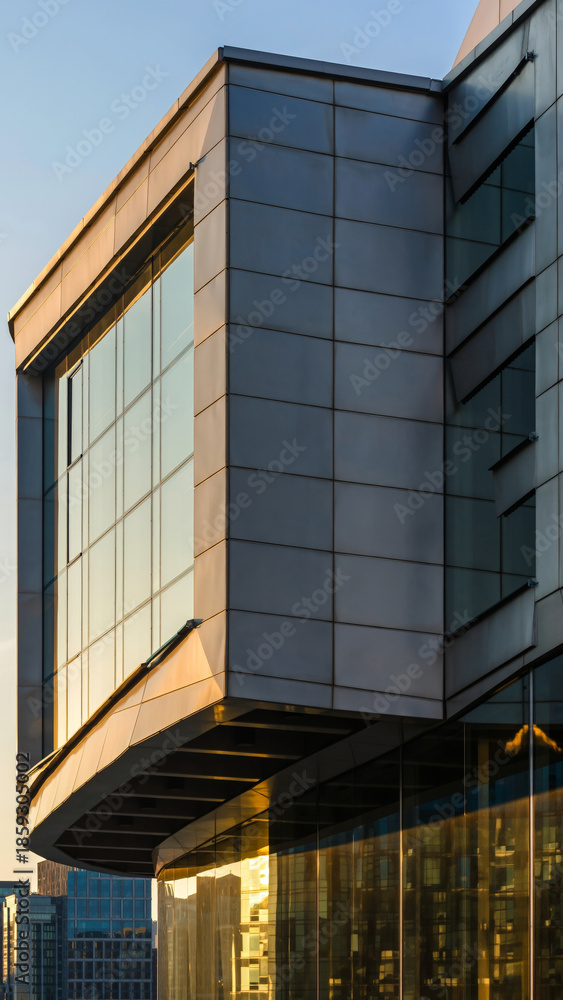 Obraz premium Modern building with large glass windows and sleek exterior panels.