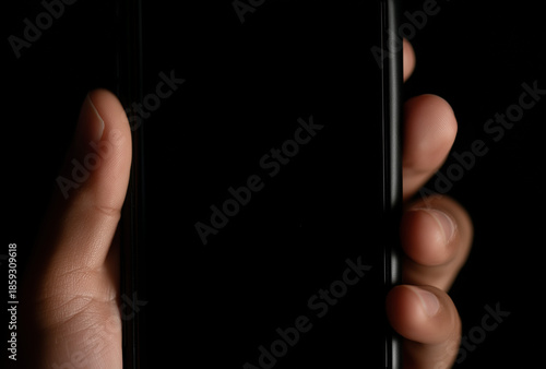 close-up of the hand holding an smartphone with a blank black screen