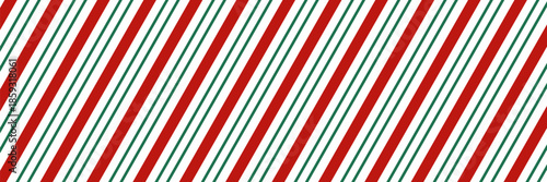 Festive pattern of Christmas candy canes. Christmas candy cane background with red and green diagonal stripes. Winter wrapping paper.