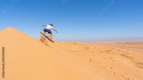 Sandboarding on desert dunes, extreme adventure sport