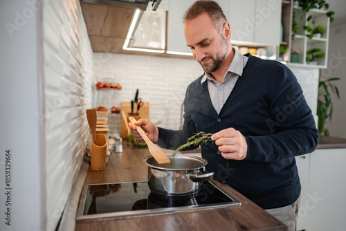 Εκτύπωση καμβά Man preparing food adding rosemary to boiling pot
