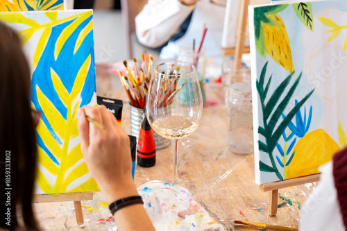 Women painting tropical scene during sip and paint event