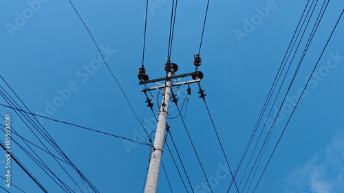 Φωτογραφία Electric utility pole with power lines crossing a clear blue sky