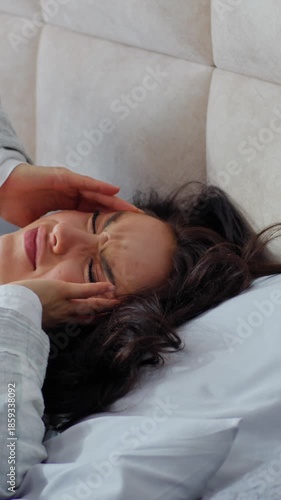 Unhealthy Caucasian woman waking up lying in bed holding head upset with headache pain symptom health difficulty female girl awaking migraine tension fever in bedroom home insomnia exhaustion tired