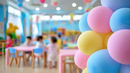 Obraz Colorful pastel balloons in decorated kindergarten with children playing in blurred background, festive atmosphere in bright and cheerful classroom with soft lighting. Selective focus.