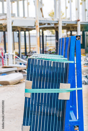  Construction site with glass panels and unfinished steel structure in background.