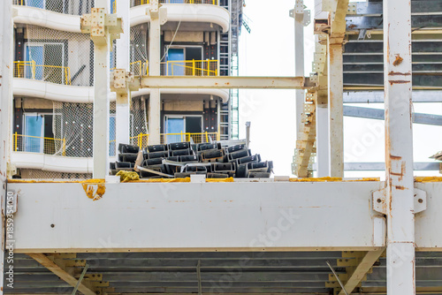 Steel frame of modern building under construction with materials on site.
