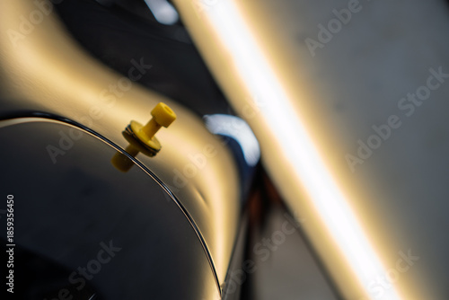 Yellow sticker with glue to make dent removal procedure at car after hail. Process of paintless dent repair on car body. The mechanic at the auto shop with tools to repair dents in car body. PDR. 