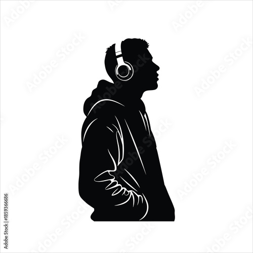 Silhouette of young man in hoodie wearing headphones outdoors