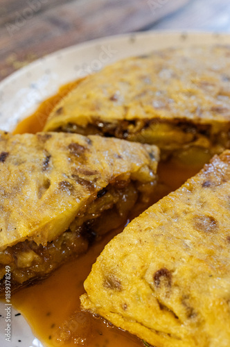 Spanish omelette slices on a plate with sauce