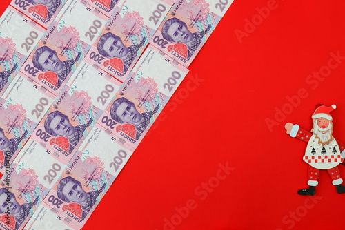 Ukrainian hryvnia, banknotes 200 hryvnias, Ukraine. Money background, money hrivna on red Christmas background and a toy Santa Claus