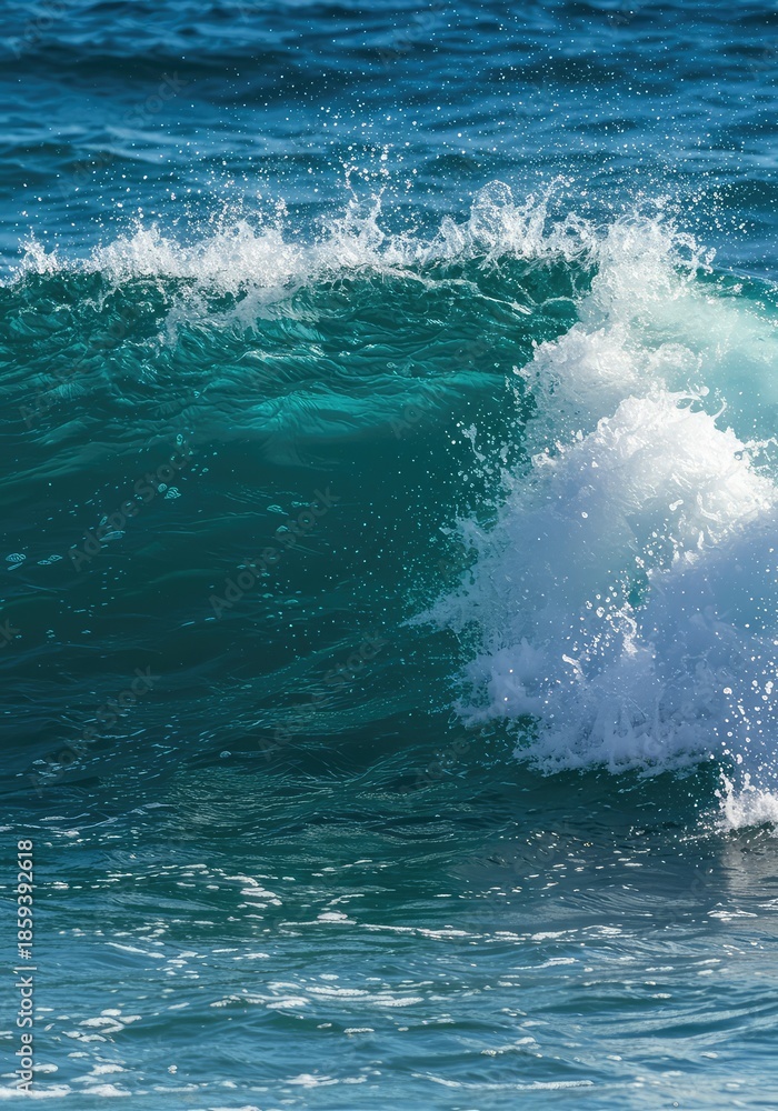 Naklejka premium Dynamic close-up view of a vibrant blue ocean wave breaking in the sunlight, creating white foam and mist during the hot summer season ,nature ,close-up ,ocean