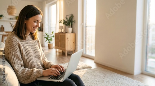 Woman working remotely on laptop in cozy living room with natural light