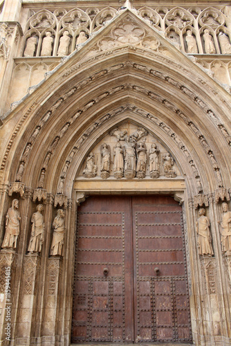 Entrance gate of Valencia Cathedral featuring historic Gothic stone architecture and religious details, taken in July 2024.